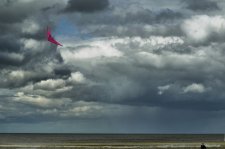 Cerf volant rose sur fond de ciel gris menaçant